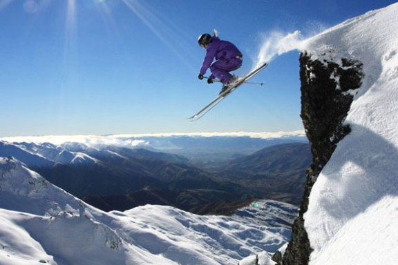 a man flying through the air on a snow covered mountain