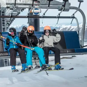 a group of people riding a ski lift on top of a snow covered mountain